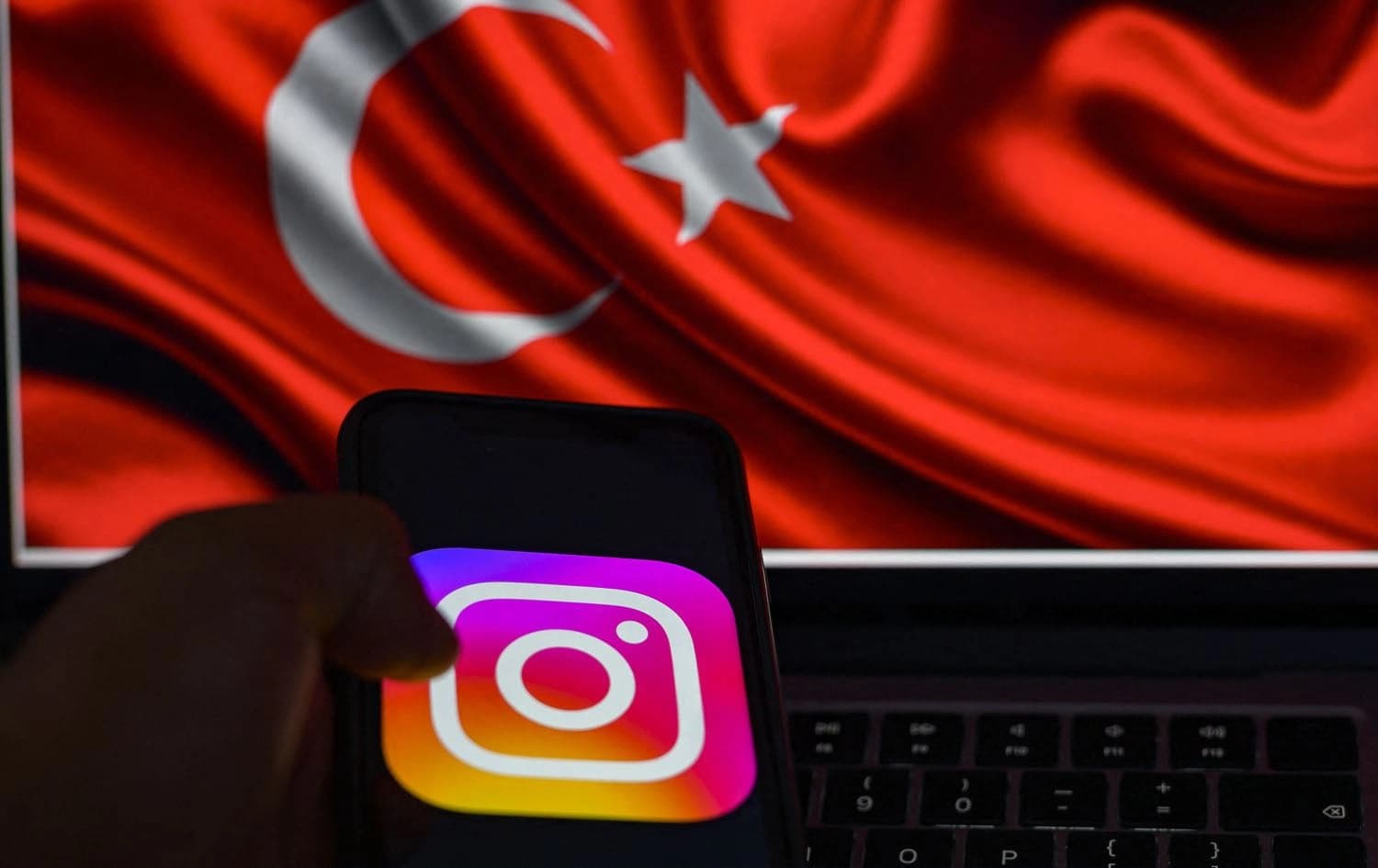 The logo of the social network Instagram on a smartphone with the Turkish flag in the background. Photo: Yasin AKGUL/AFP