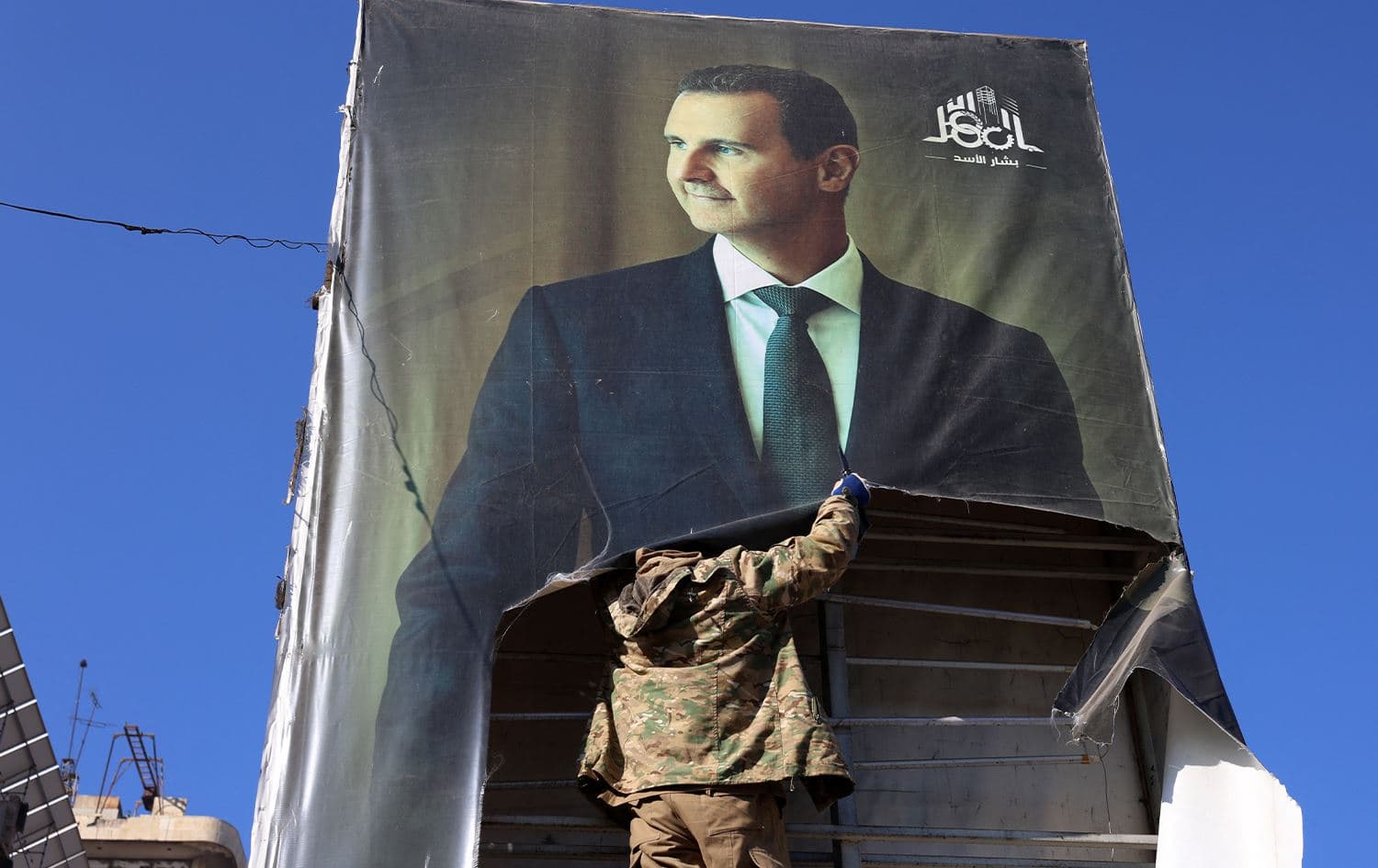 An anti-government fighter tears down a portrait of Syria's President Bashar al-Assad in Aleppo, after jihadists and their allies entered the northern Syrian city, on November 30, 2024. Photo: Mohammed al-Rifai/AFP