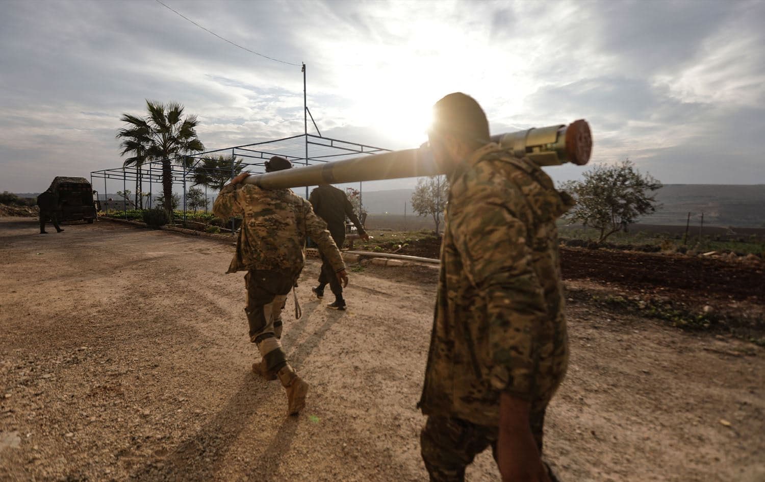 Anti-government fighters carry a rocket to be used against regime forces, in the northern outskirts of Syria's west-central city of Hama on December 4, 2024. Photo: BAKR AL KASSEM/AFP