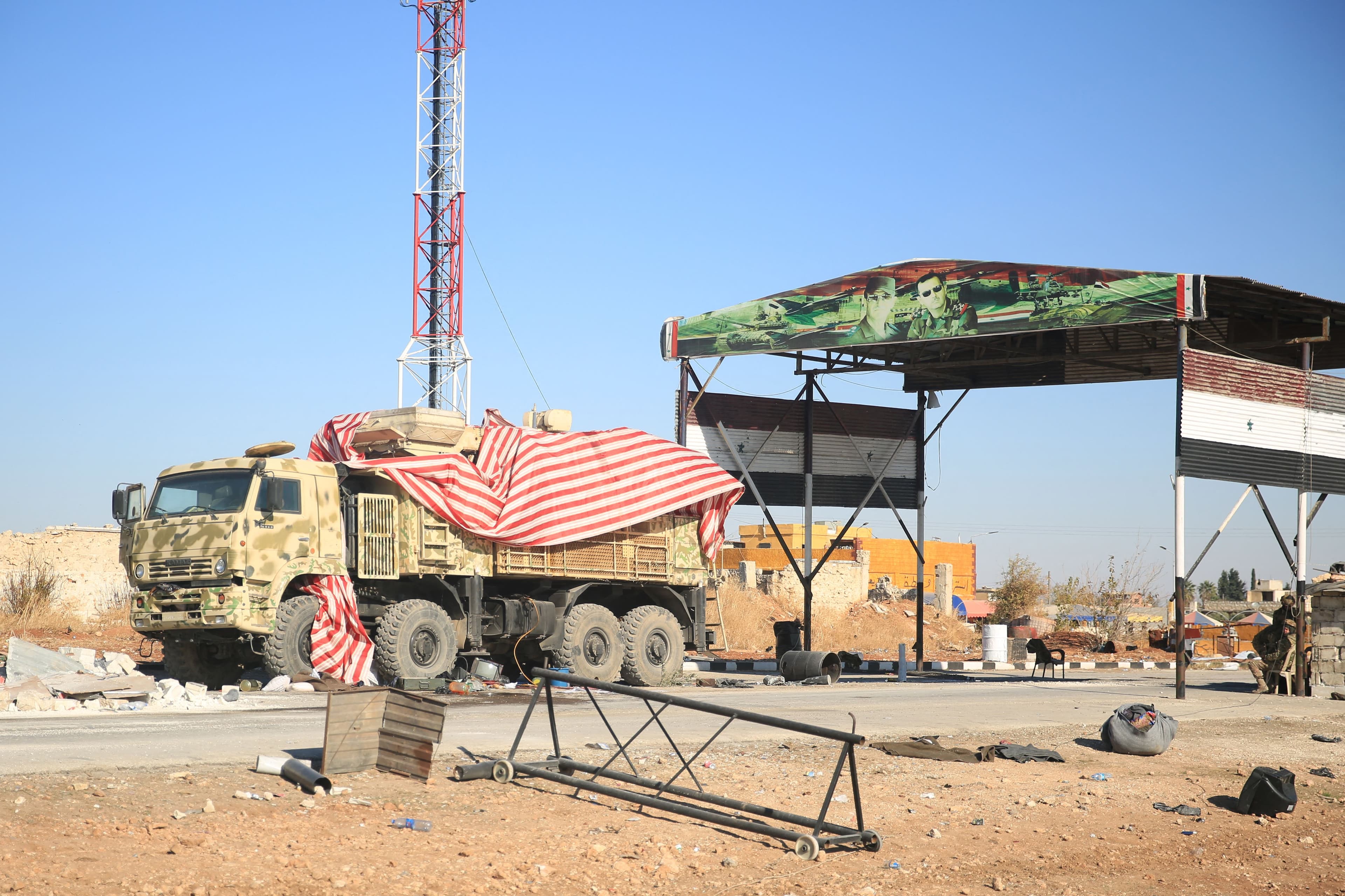Anti-government fighters stand near a Syrian army truck abandoned along a road in the eastern part of Aleppo province on December 1, 2024. Photo: AFP