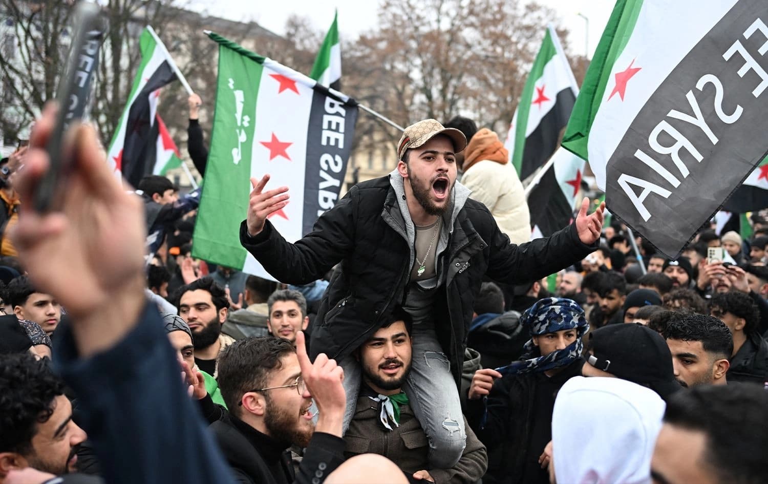 Syrians celebrate the fall of the Bashar al-Assad regime and wave the Syrian flags in Berlin, Germany on December 8, 2024. Ralf Hirschberger/AFP