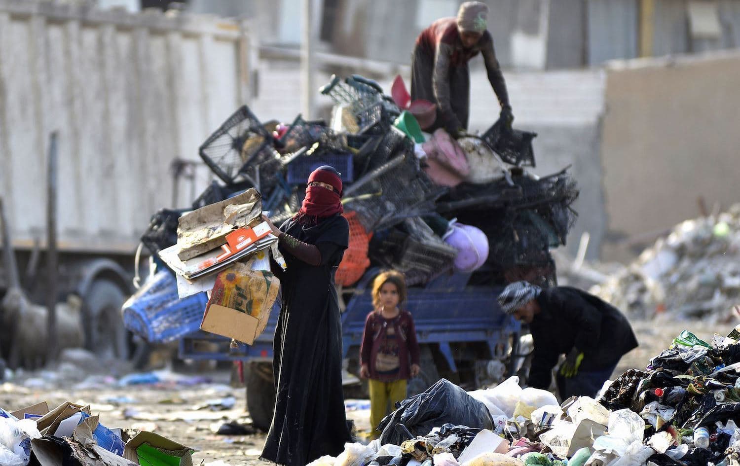 ئافرەتێک لە نێو پاشماوەکان کارتۆن کۆدەکاتەوە. وێنە: AFP/ئەرشیڤ