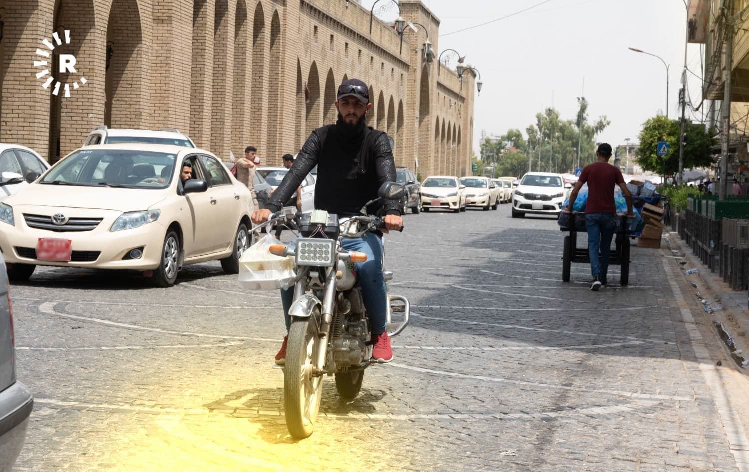 ماتۆڕسوارێک لەنێو بازاڕی هەولێر خواردن دەگوازرێتەوە