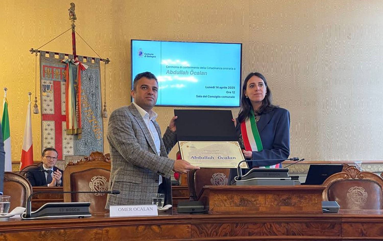 Omer Ocalan (left) receiving Abdullah Ocalan’s honorary citizenship from Bologna Deputy Mayor Emily Clancy (right) on April 14, 2025. Photo: Omer Ocalan/X