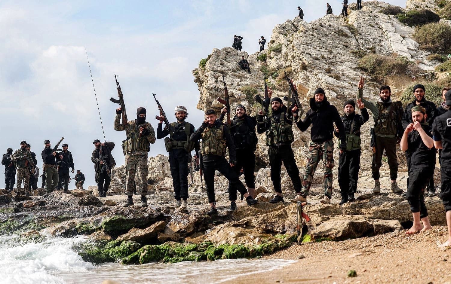 Members of security forces loyal to the interim Syrian government pose together with their firearms as they stand along a rocky beach by the Mediterranean sea coast in Syria's western city of Latakia on March 9, 2025. Photo: AFP