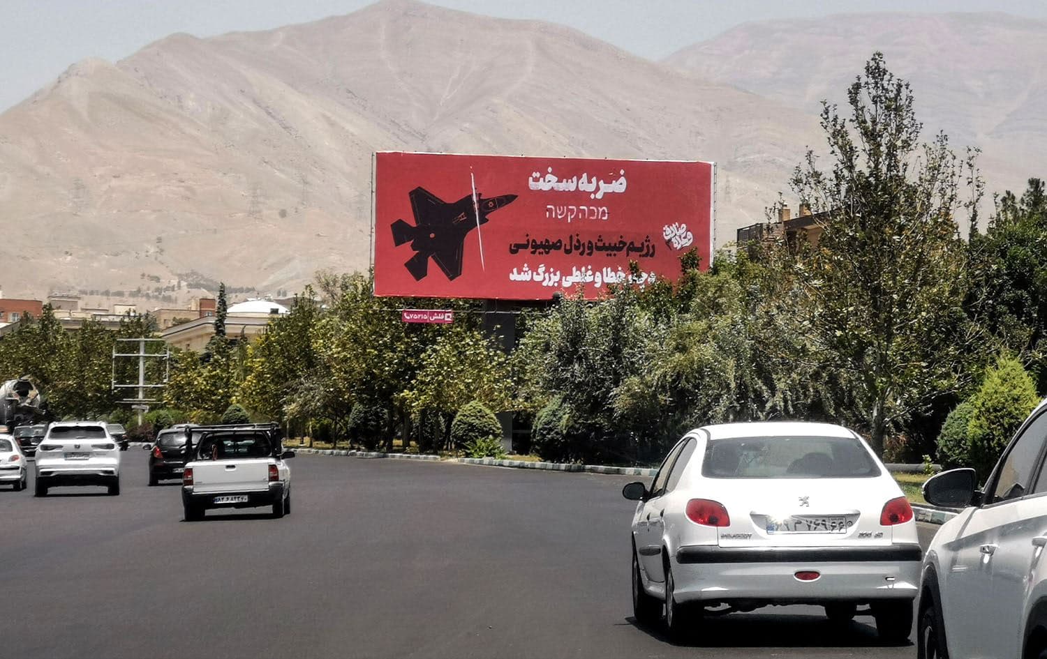 Commuters drive past an anti-Israel billboard in Tehran, on June 22, 2025. Photo: Atta Kenare/AFP