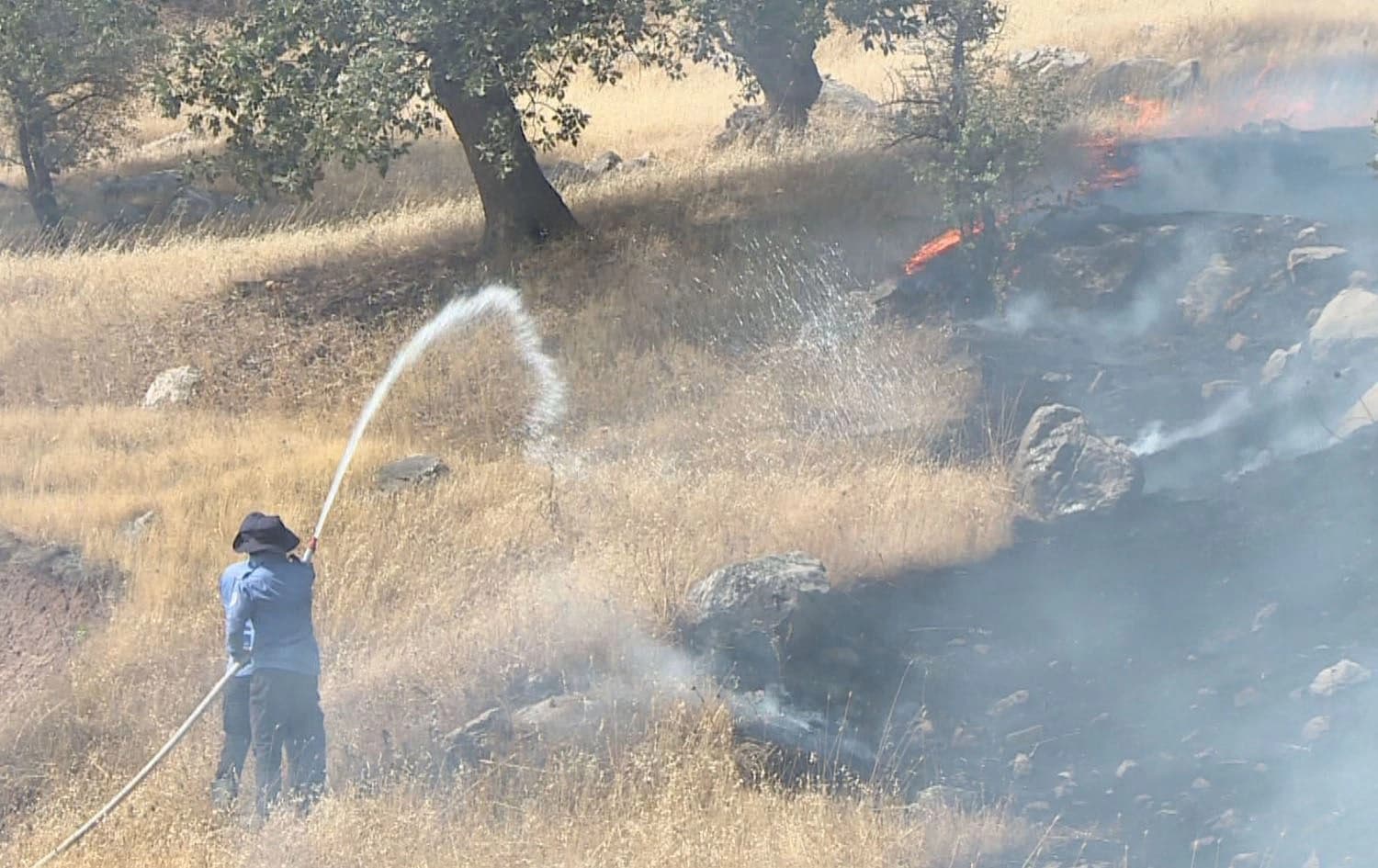 A man attempts to put out a fire in the Kurdistan Region’s Sulaimani province on June 30, 2025. Photo: Rudaw