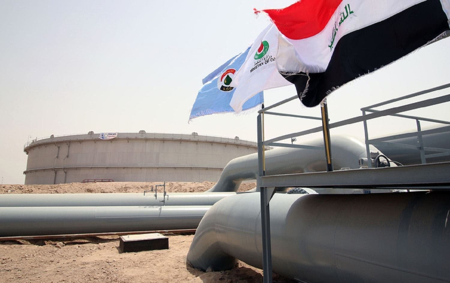 Flags flutter in front of an oil tank at al-Faw storage terminal, Basra province. File photo: AFP