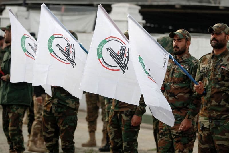 Members of Iraq’s Popular Mobilisation Forces (PMF) carry their flags in western Iraq in January 2024. AFP file photo
