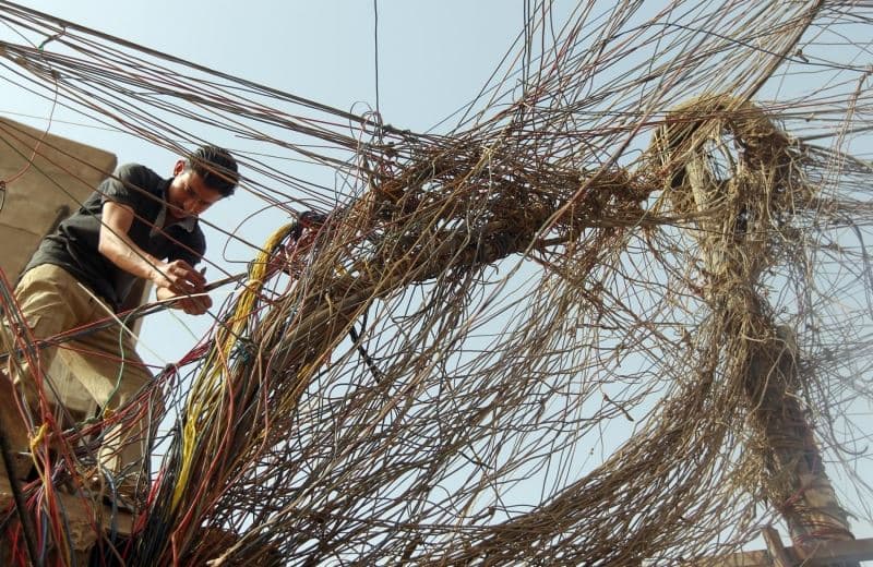 An Iraqi worker fixes wiring linked to a generator which provides electricity to a residential neighborhood in Baghdad during power cuts. AFP file photo