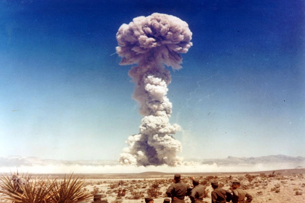 وێنەکە تاقیکردنەوەیەکی چەکی ئەتۆمیی "دۆگ" لە ساڵی 1951 لە نێڤادای ئەمریکایە. ئەمە تاقیکردنەوەیەکی 21 کیلۆتۆنی بوو، کە تێیدا سەربازان لە دوورییەوە تەقینەوەکەیان چاودێری کرد.