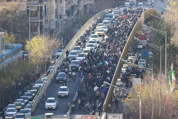 Shopkeepers and traders walk over a bridge during a protest against Iran's economic conditions and plummeting currency in Tehran on December 29, 2025. Photo: Fars News Agency