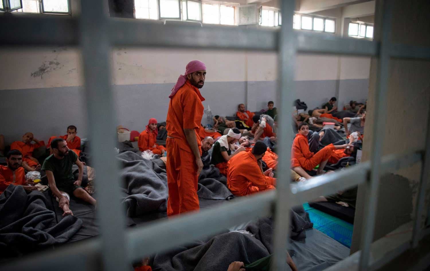 Men allegedly affiliated with ISIS sit on the floor in a prison in the northeastern Syrian city of Hasaka on October 26, 2019. File photo: AFP
