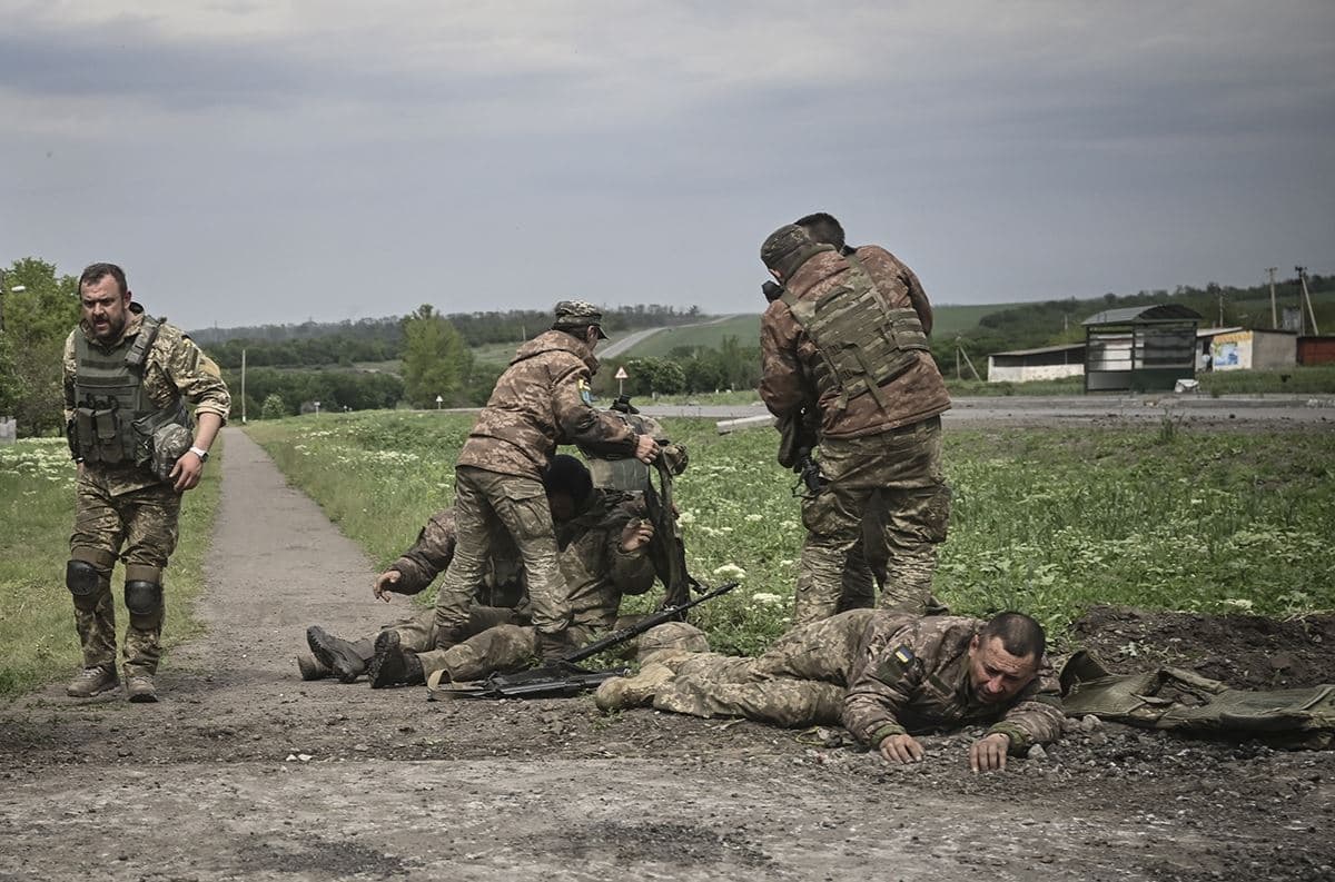 Ukrainian troops help wounded comrades not far from the front line in the Donbas, eastern Ukrainian, on May 21, 2022. AFP file photo