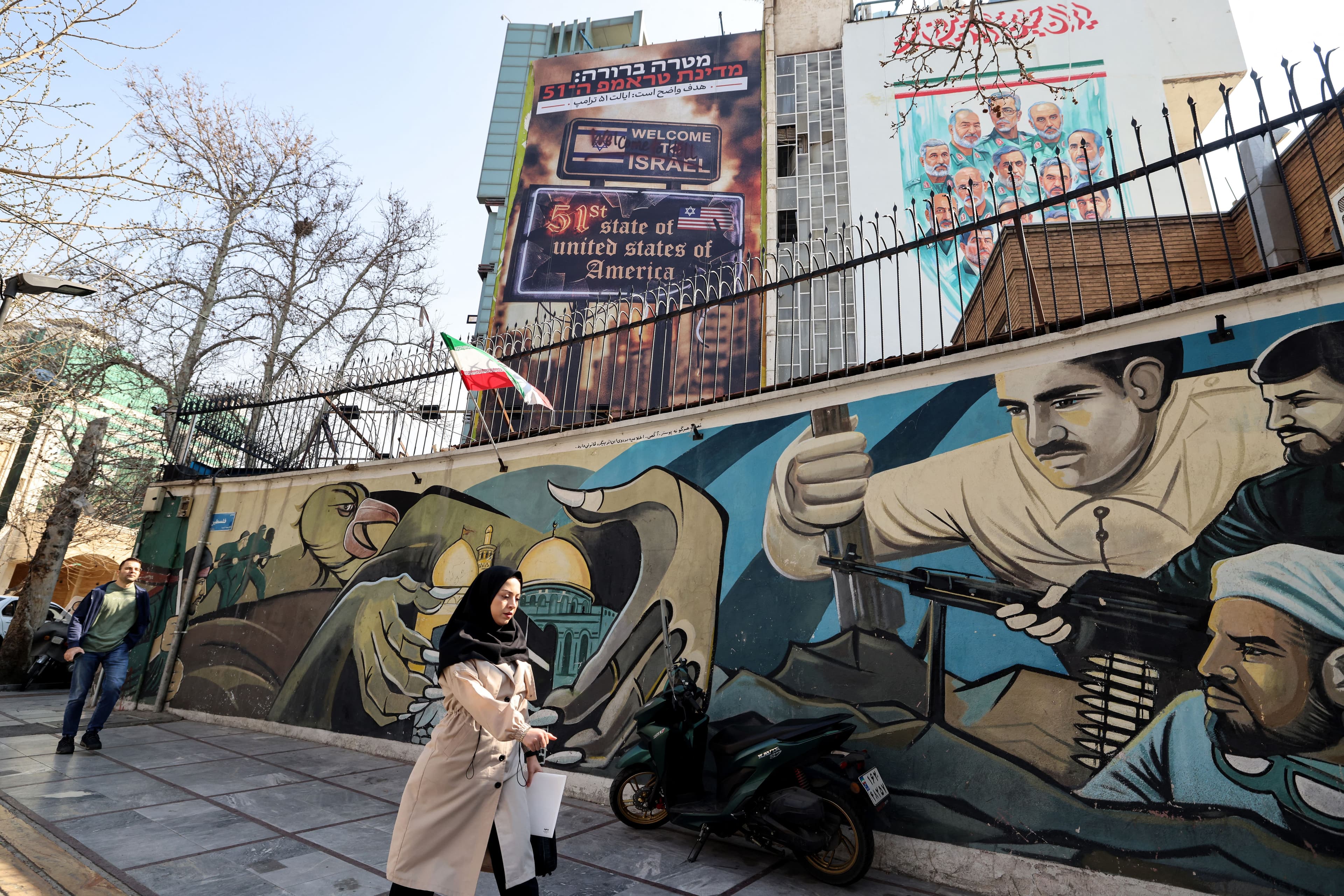 A woman walks past an anti-Israeli and anti-US billboard hanging from a building that reads in Persian "The target is clear: Trump's 51st state" on Palestine Square in Tehran on February 25, 2026. Photo: AFP
