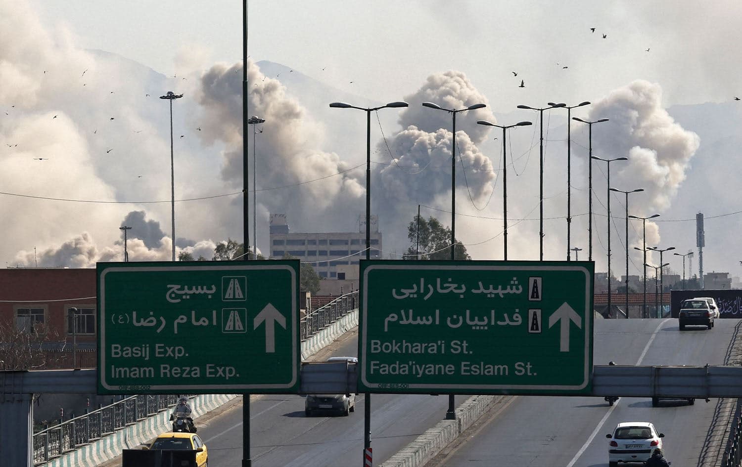 Vehicles drive along an expressway against the backdrop of smoke rising after a strike on the Iranian capital of Tehran on March 5, 2026. Photo: Atta Kenare / AFP