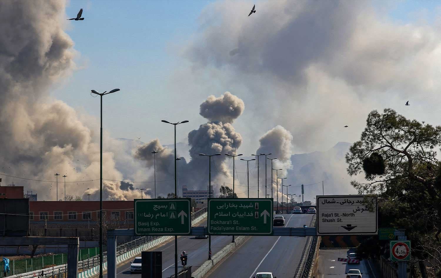 Motorists drive along an expressway as plumes of smoke rise after a strike in Tehran on March 5, 2026. Photo: AFP