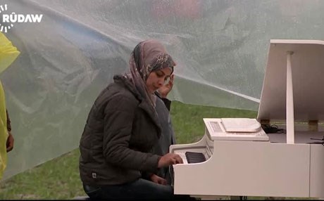 بەڤیدیۆ.. كچە كۆچبەرێك لەنێوان یۆنان و مەكدۆنیا پیانۆ دەژەنێت