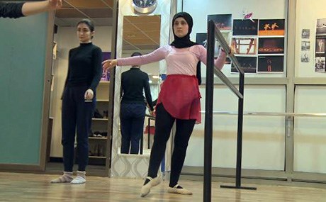 لە سلێمانی کچێک بە سەرپۆشەوە سەمای بالێ دەکات