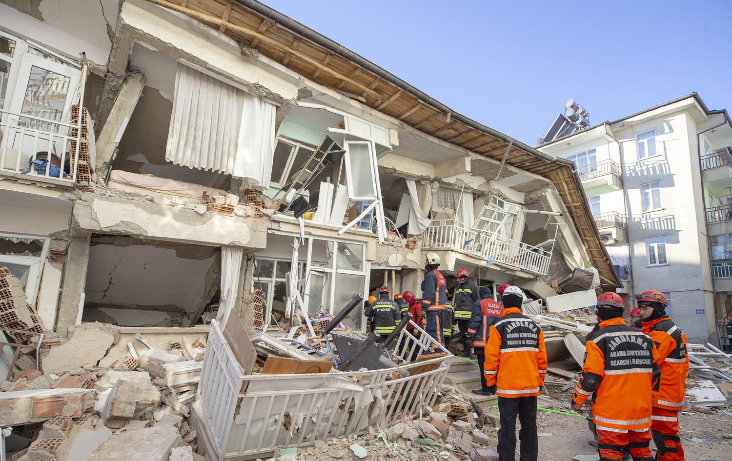 تیمەکانی فریاگوزاری لەکاتی گەڕان بەدوای قوربانییاندا لەژێر باڵەخانە رووخاوەکاندا. AA