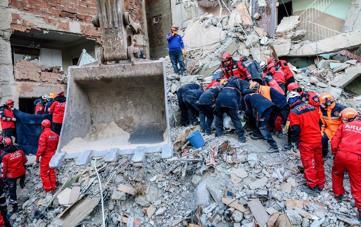 کارمەندانی فریاگوزاری لەکاتی هەوڵدان بۆ رزگارکردنی قوربانیان. وێنە: AFP