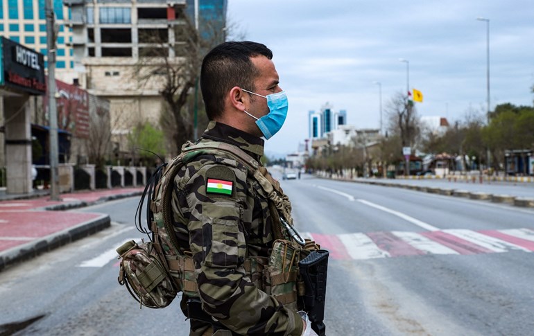A member of the Asayish stands at a security checkpoint in the city of Sulaimani, March 14, 2020. Photo: Shwan Mohammed / AFP