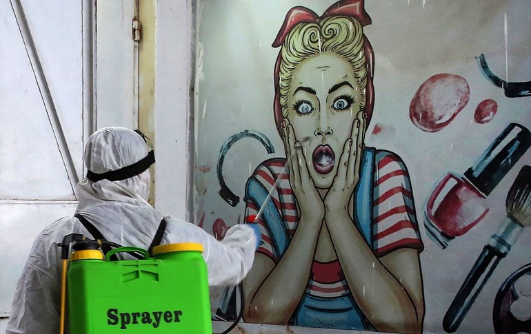 A volunteer disinfects a shop in Baghdad's Bayaa neighbourhood, March 21, 2020. Photo: Ahmad al-Rubaye / AFP
