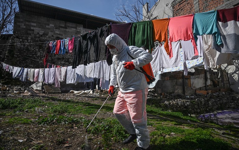 A member of the Fatih Municipality disinfects a garden at a home along a street in Istanbul to prevent the spread of the novel coronavirus, COVID-19, on March 20, 2020. Photo: Ozan Kose / AFP