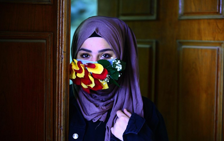 A woman is seen wearing a mask embellished with petals in the central Iraqi holy city of Najaf on March 21, 2020 amid the COVID-19 coronavirus pandemic. Photo: Haidar Hamdani/ AFP