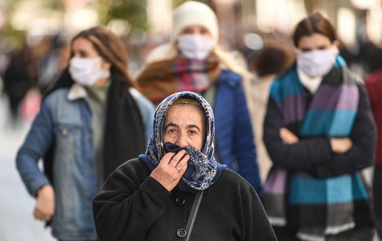 People wear protective face masks as they walk along Istiklal Avenue, Istanbul on March 17, 2020. Photo: Ozan Kose / AFP 