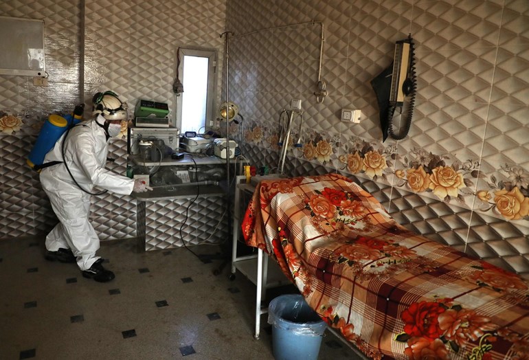 A member of the Syrian Civil Defence known as the "White Helmets" disinfects a hospital room. Photo: Aaref Watad