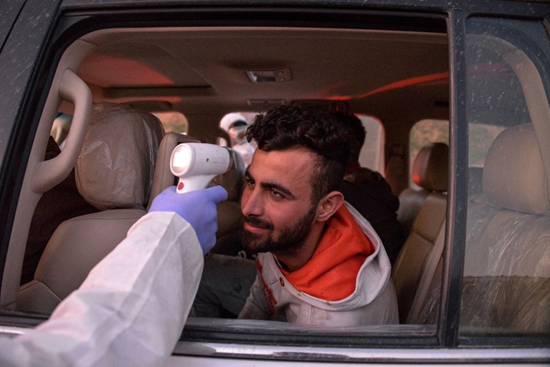  An Iraqi health ministry worker scans the body temperature of a passenger in an incoming vehicle in Iraq's northern city of Mosul on March 8, 2020. Photo: Zaid Al-Obeidi/ AFP