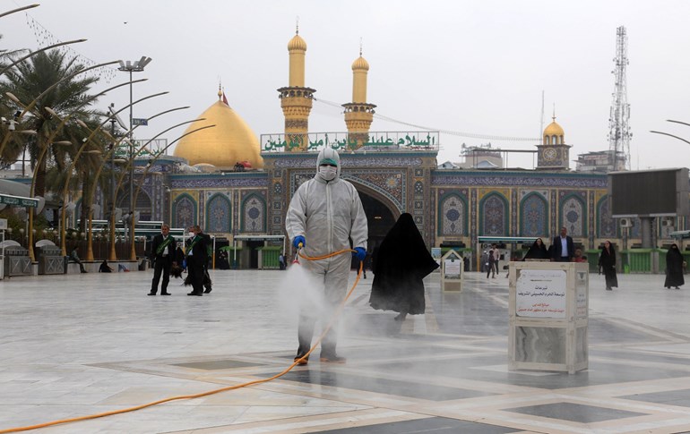 Health workers disinfect the area around the Imam Hussein Shrine in the holy shrine city of Karbala on March 15, 2020. Photo: Mohammed Sawaf/AFP