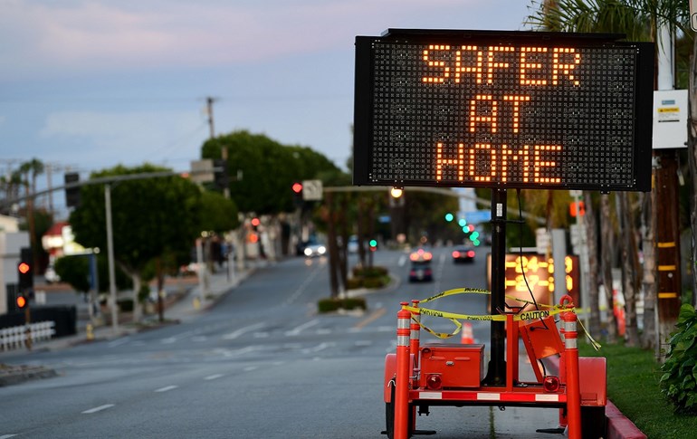 A sign reminds residents it is ‘Safer at Home’ on the quiet streets of Monterey Park, California, March 26, 2020. Photo: Frederic J. Brown / AFP
