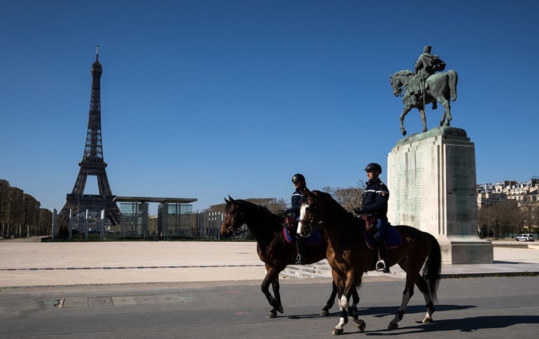French mounted police patrol with the Eiffel Tower in background in Paris on March 25, 2020. Photo: Joel Saget/AFP