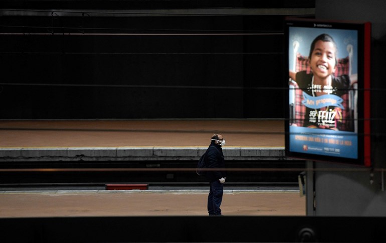 A man wearing a face mask stands on a platform of Atocha railway station in Madrid on March 30, 2020. Photo: Oscar del Pozo/AFP