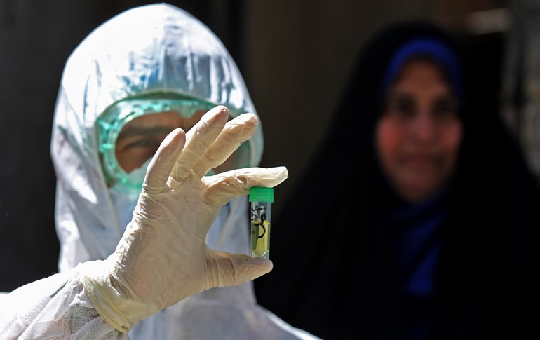 An Iraqi doctor shows a tube containing a swab used for testing a resident for COVID-19 in the Baghdad suburb of Sadr City on April 2, 2020. Photo: Ahmad al-Rubaye / AFP