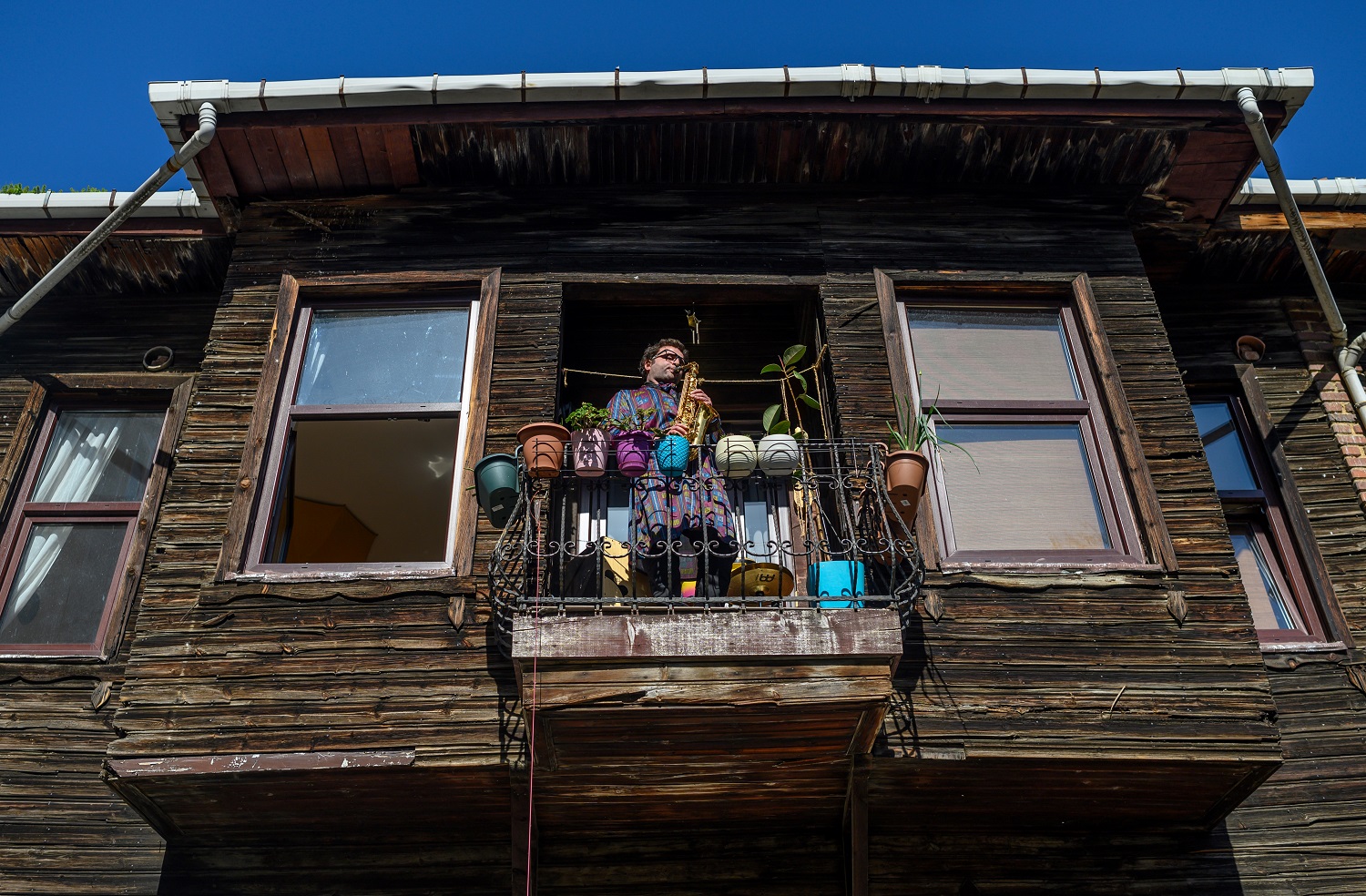 Musician Alper Kalaycioglu holds a concert for his neighbours and social media followers in Kadikoy district, Istanbul, on April 8, 2020. Photo: Bulent Kilic/ AFP