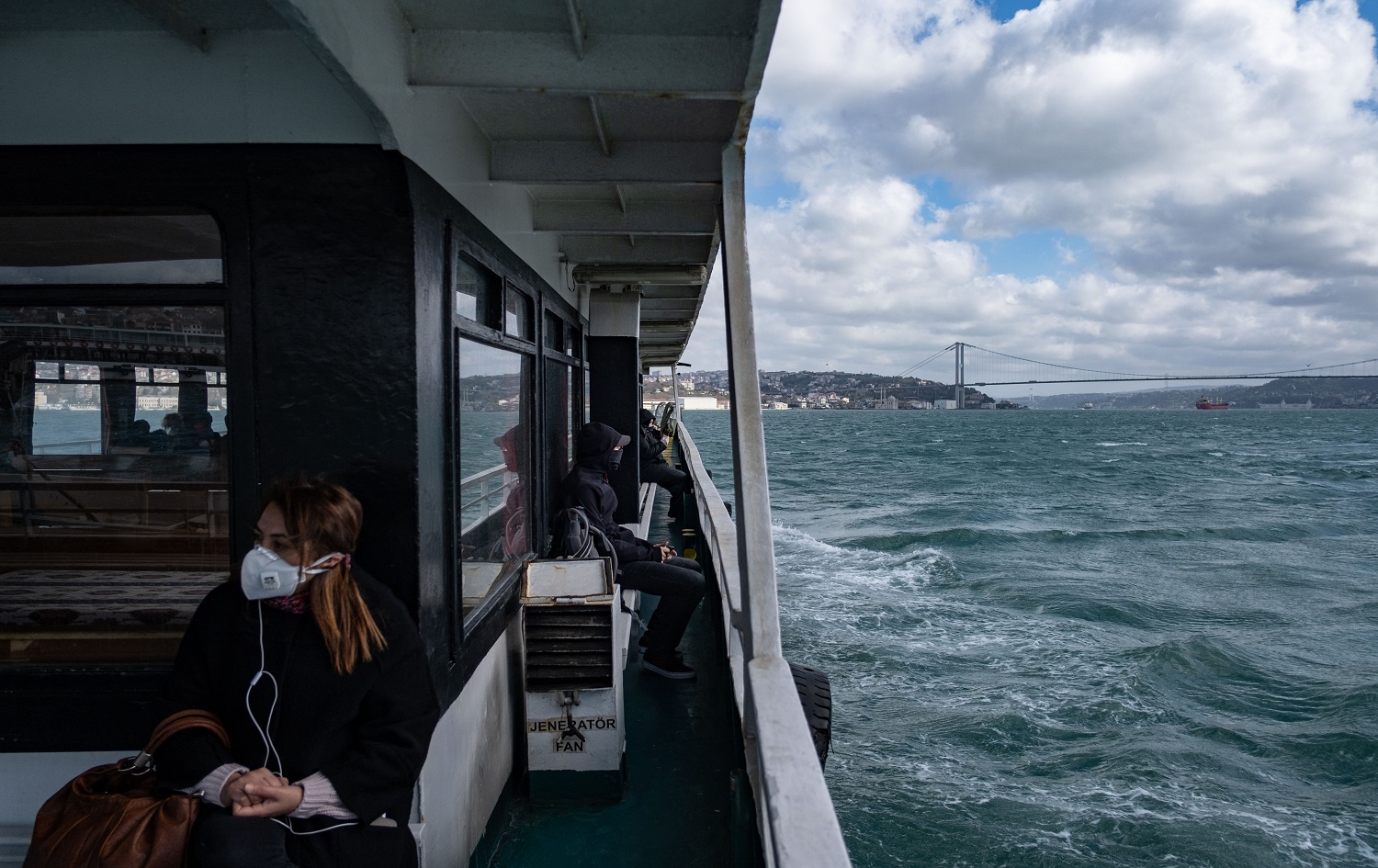 A woman wearing a protective face mask travels on a ferry across the Bosphorus in Istanbul on April 8 April 2020. Photo: Yasin AKGUL / AFP