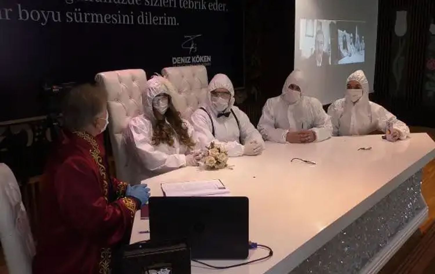 Sağlıkçı çift koruyucu tulum giyerek nikah masasına oturdu