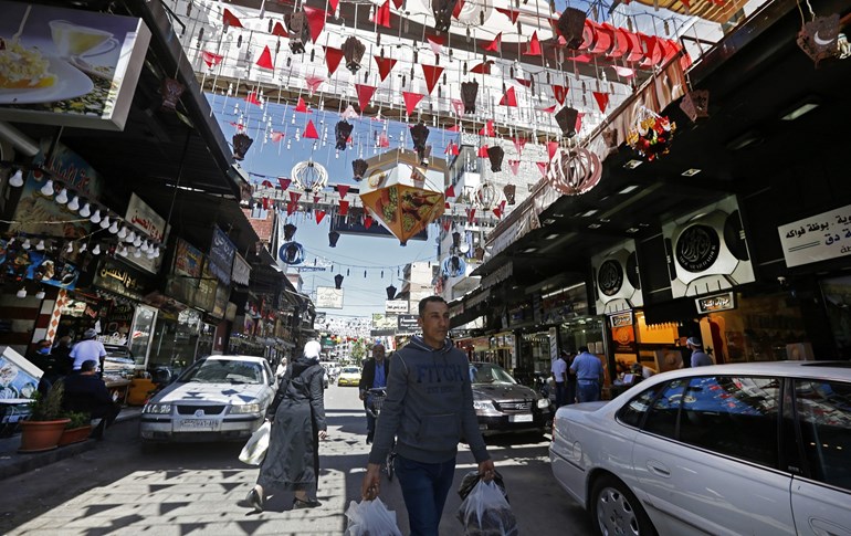 Syrians shop at the Maidan market in Damascus on April 26, 2020. Photo: Louai Beshara/ AFP   	