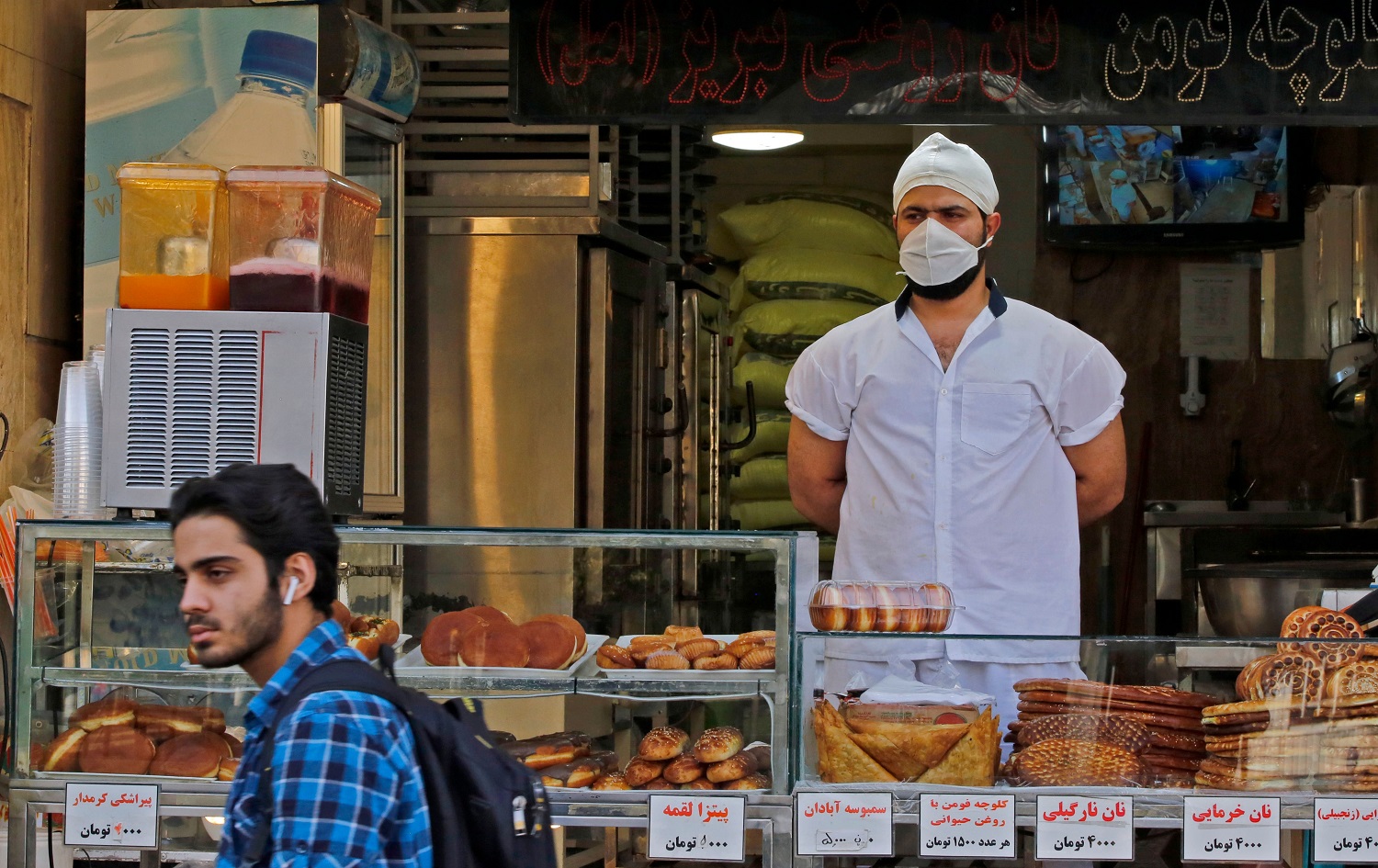 An Iranian man walks in front of a pastry shop in the capital Tehran on June 3, 2020. Photo: AFP  	