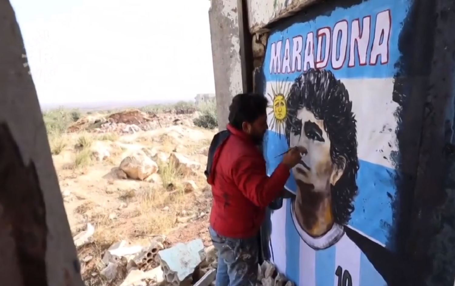 Hunermendekî Sûrî wêneyê Maradona li ser dîwarê kavilekê çê kir