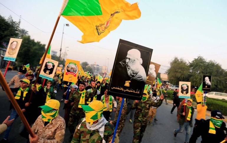 عناصر من كتائب حزب الله العراقي يحملون صور سليماني والمهندس 