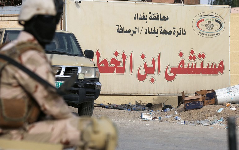 اد: عناصر من قوات الأمن العراقية يقفون على بوابة مستشفى ابن الخطيب في بغداد - AFP / AHMAD AL-RUBAYE