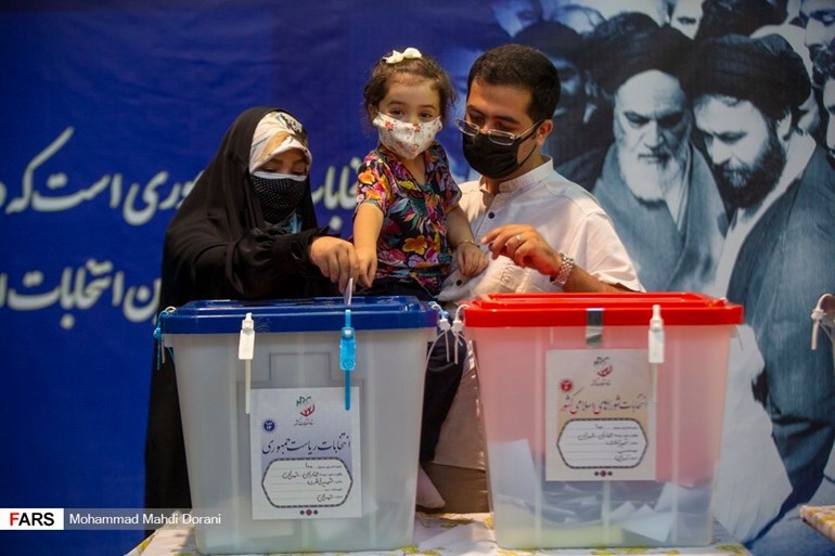 ژن و پیاوێک لە کاتی دەنگدان لە هەڵبژاردنی سەرۆکایەتیی کۆماری ئێران