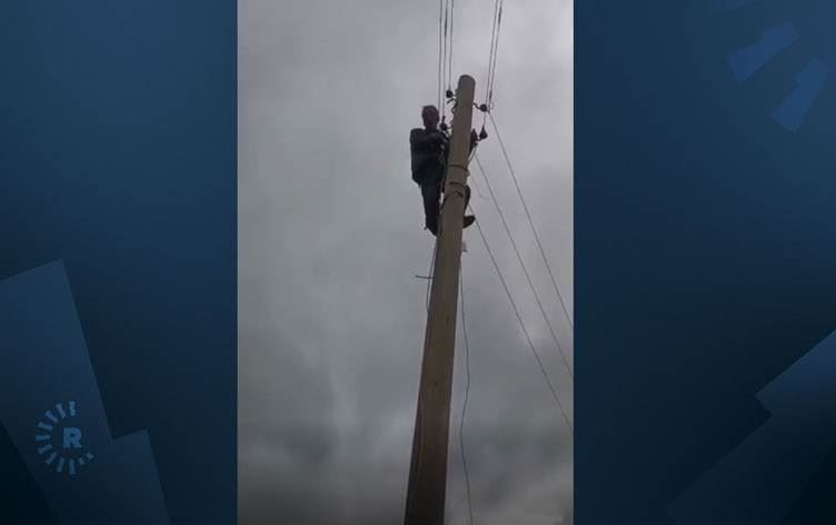 Muxtar ji bo protestkirina nebûna xizmetguzariyan derket ser stûna elektirîkê