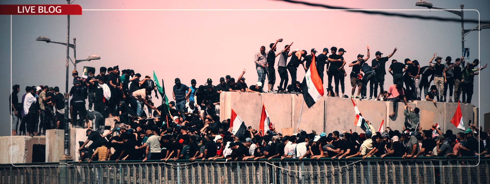 لایەنگرانی سەدر وێنەی موقتەدا سەدرییان بەرزکردووەتەوە و بەربەستێکی کۆنکرێتییان بڕیوە. وێنە Ahmad Al-Rubaye / AFP