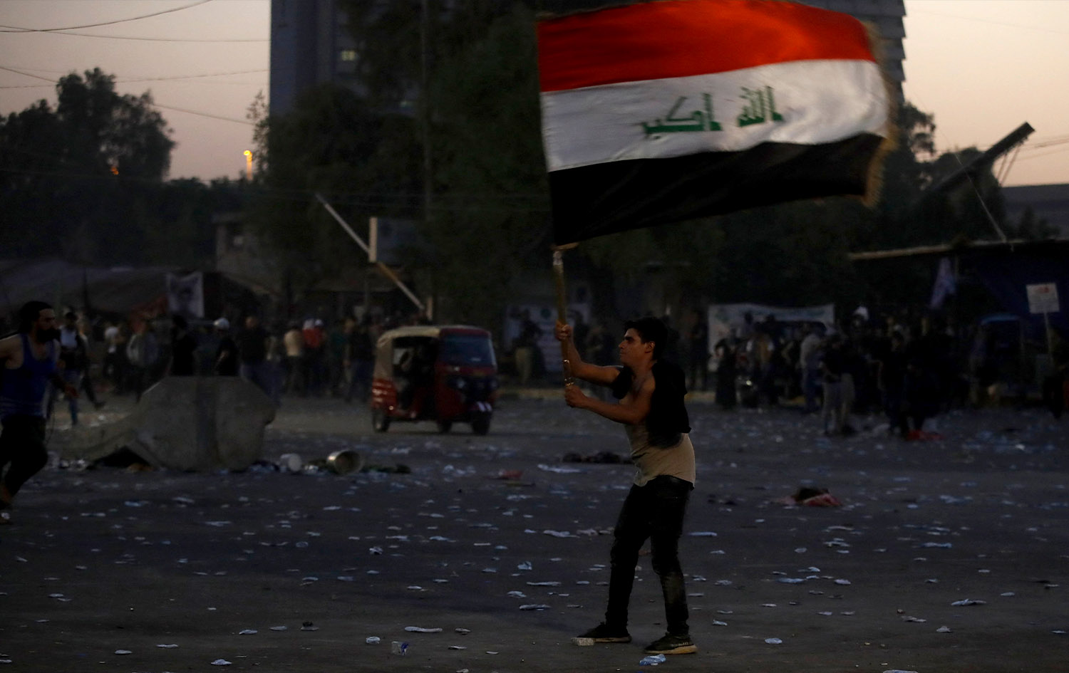 لایەنگرێکی سەدر لە خۆپێشاندانەکانی بەغدا ئاڵای عێراقی بەرزکردووەتەوە. وێنە: AFP