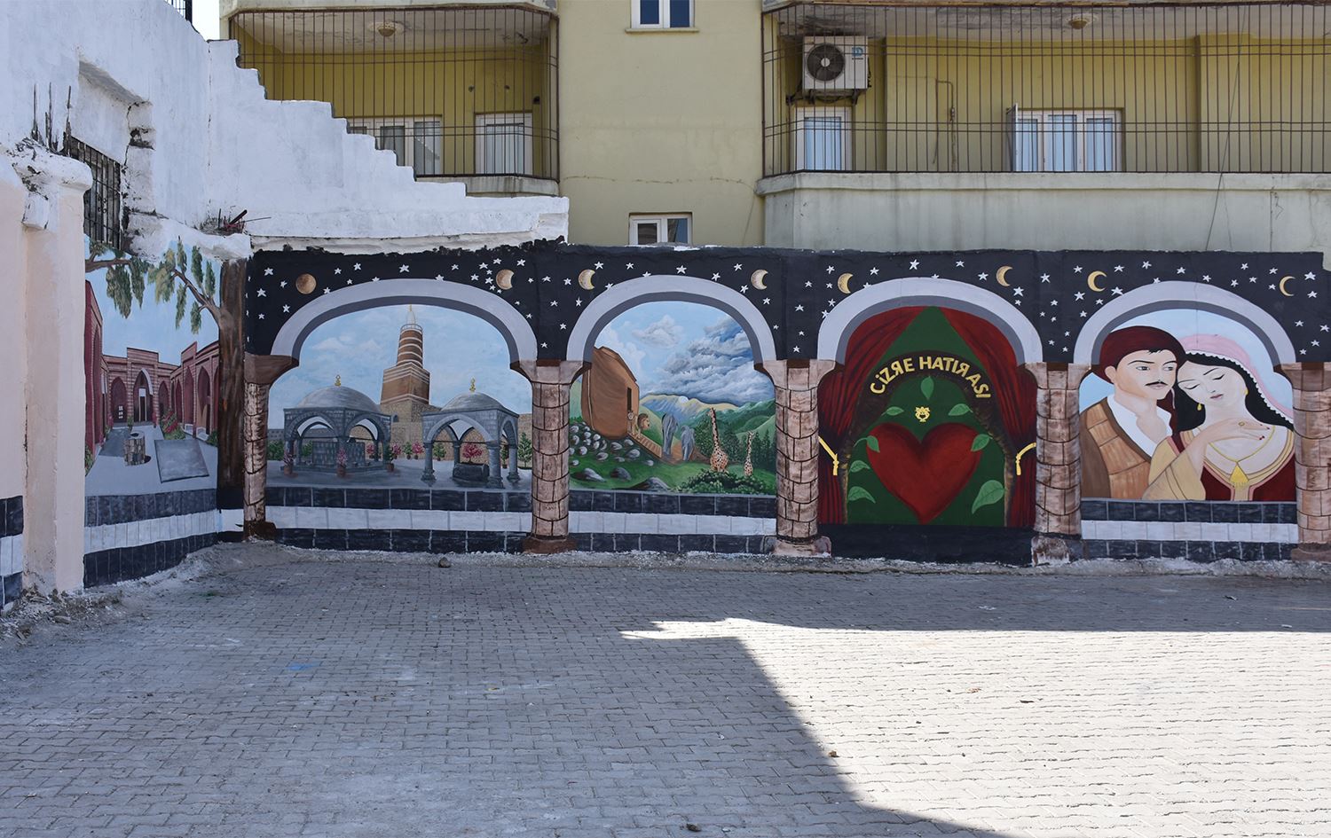 Li Cizîrê wênesazekî Kurd dîwarên bajêr bi wêneyên dîrokî di xemilîne